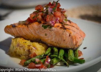 Commercial food photography of plated salmon in waterfront restaurant