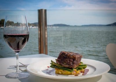 Commercial photography of beer and wine with a view at waterfront restaurant